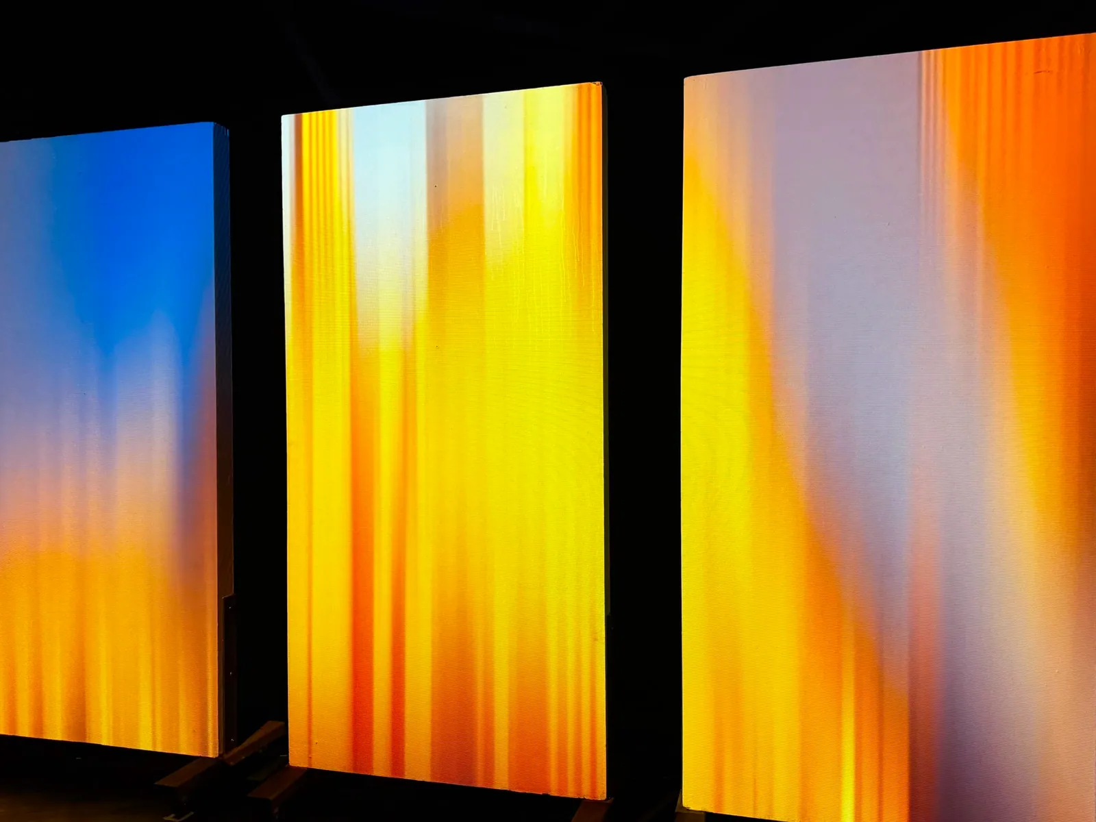 Close view of panels with vertical streaks of yellow, orange and blue light, Nocturnal installation