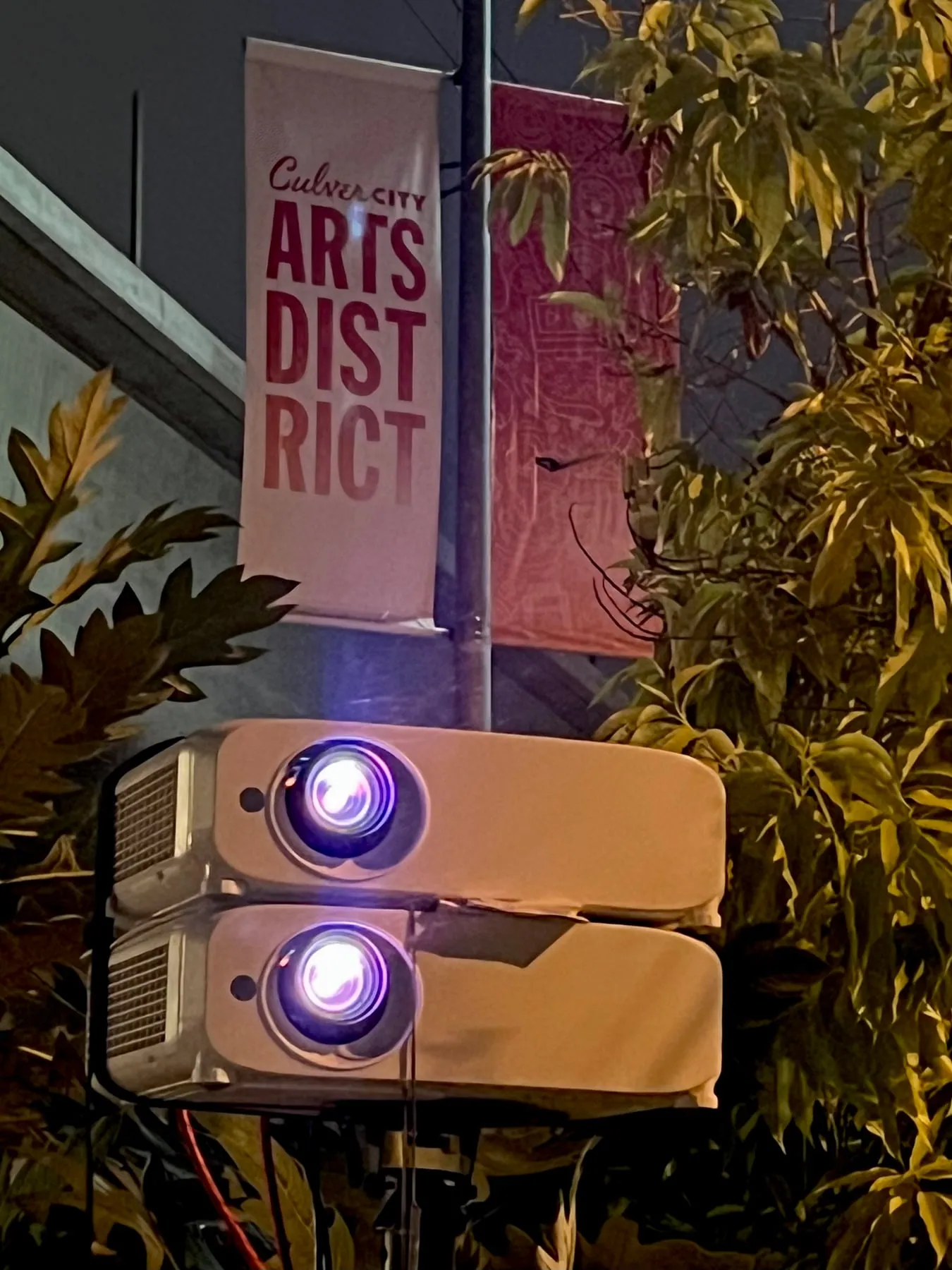 Two stacked projectors beneath a Culver City Arts District banner