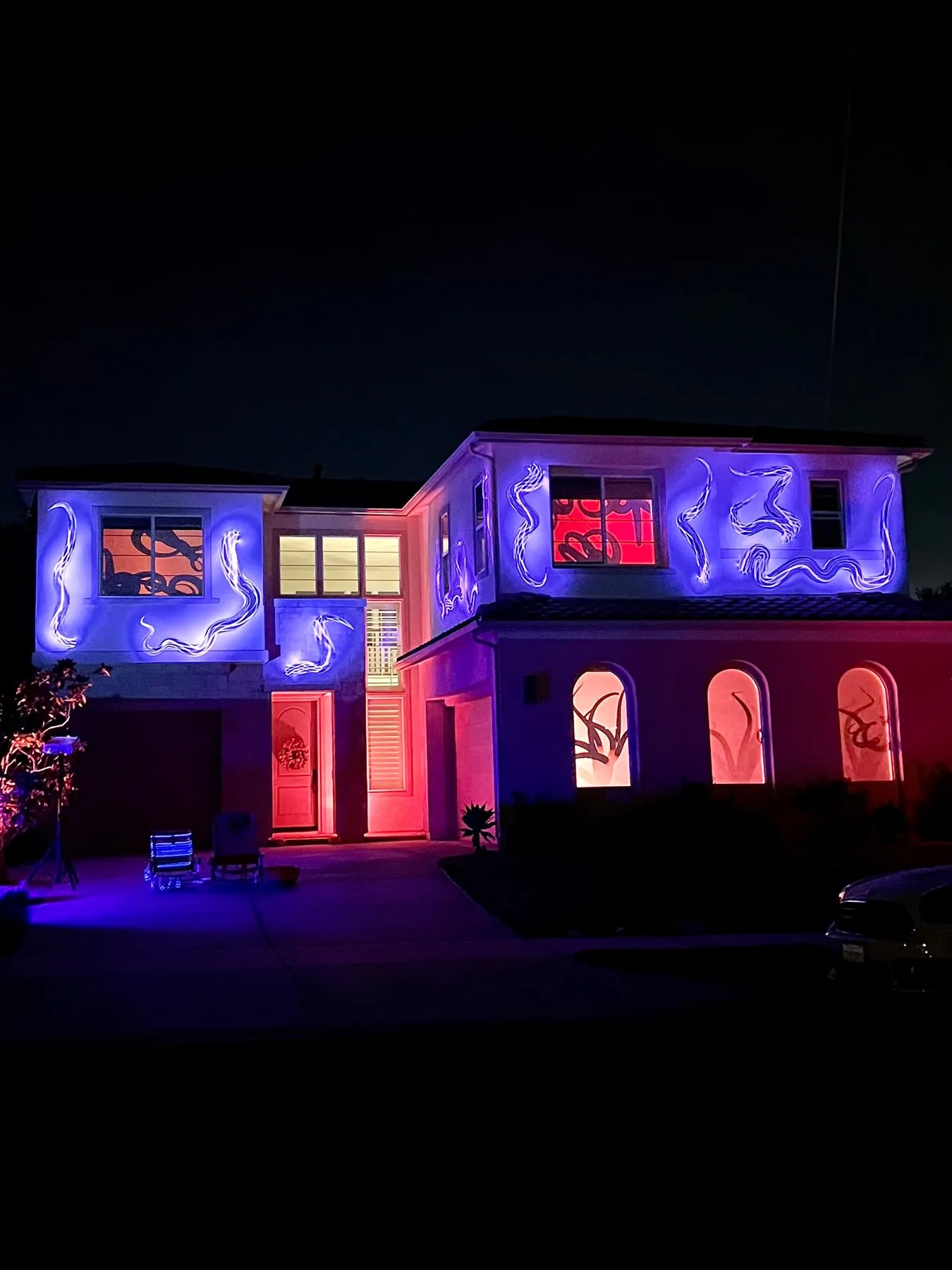 Full house facade with projected tentacles writhing behind the windows, Halloween 2021