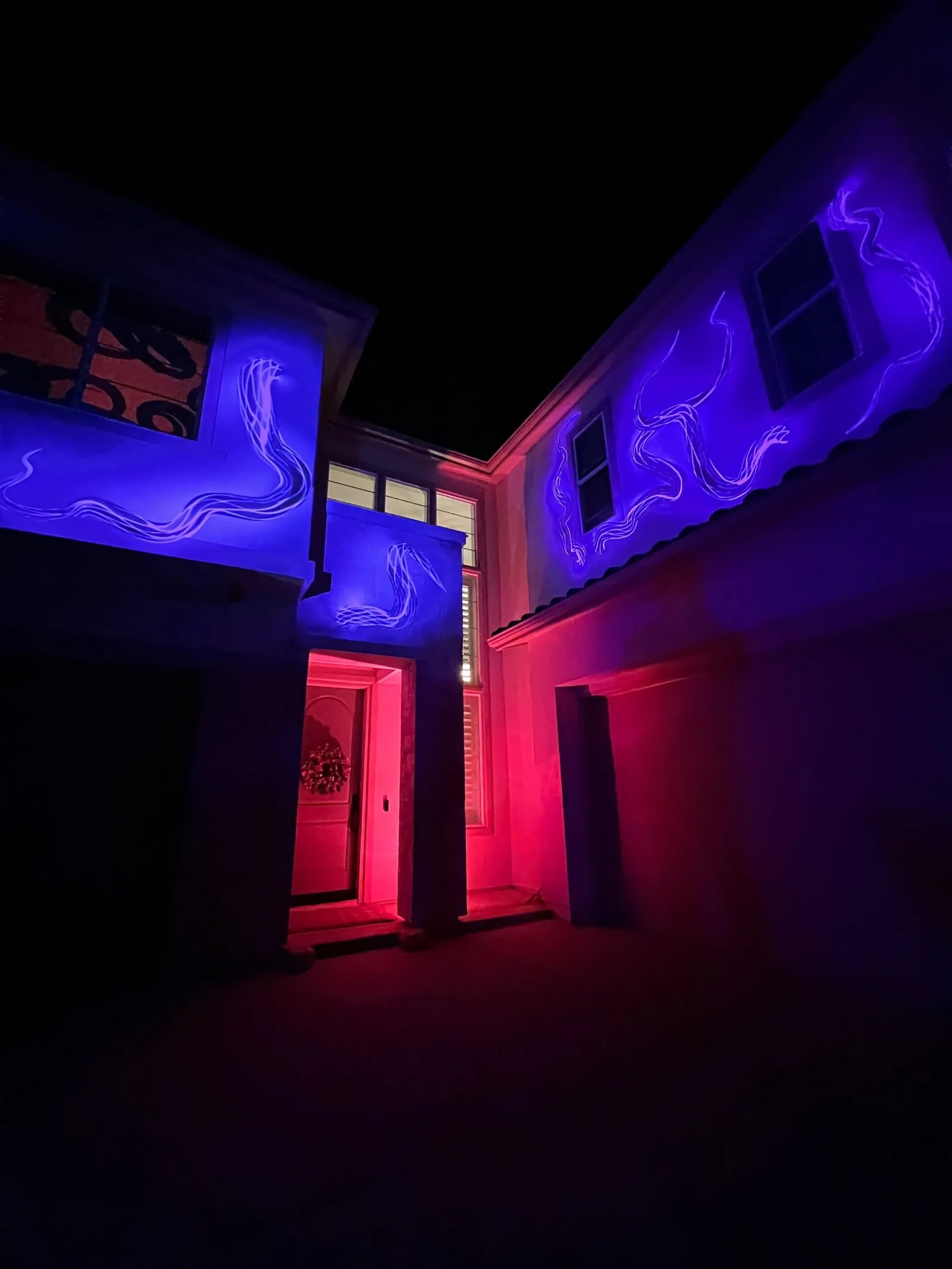 Angled view of a house with purple tentacle projections and a red-lit doorway, Halloween 2021