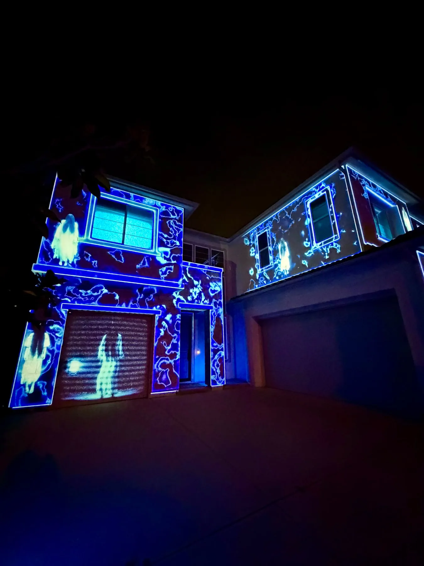 Angled view of a house mapped with blue distortion and spectral figures, Halloween 2025